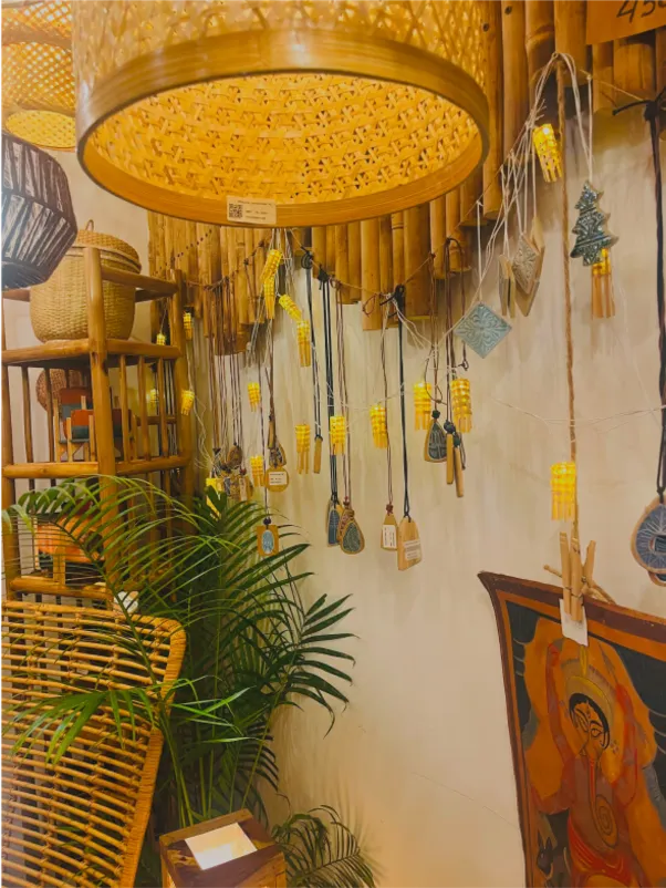 A café wall hung with guitars and plants under a woven lamp.