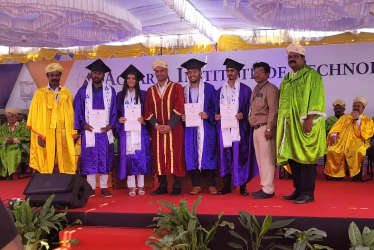 Graduates on stage at a convocation ceremony.